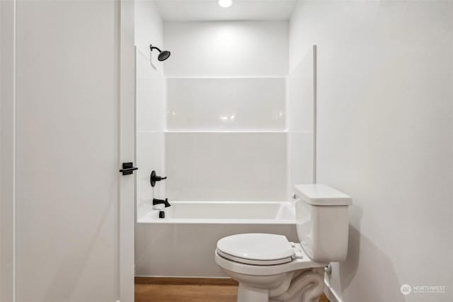 bathroom featuring tub / shower combination, hardwood / wood-style floors, and toilet