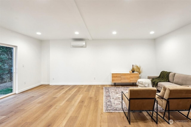 sitting room with light hardwood / wood-style floors and a wall unit AC