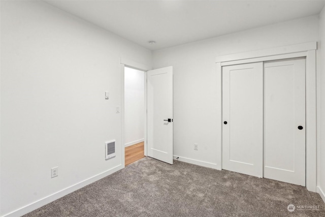 unfurnished bedroom with a closet and carpet flooring