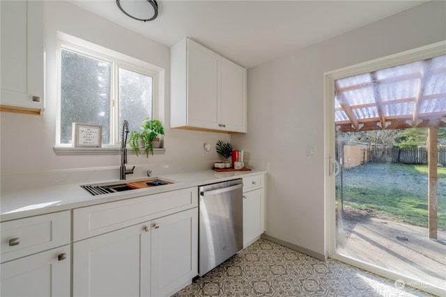 kitchen featuring stainless steel dishwasher, sink, and white cabinets