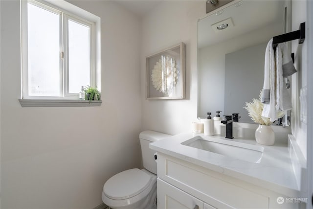 bathroom with vanity, a wealth of natural light, and toilet