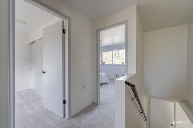 hallway featuring light colored carpet