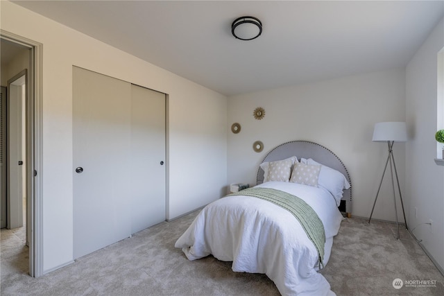 bedroom with light carpet and a closet