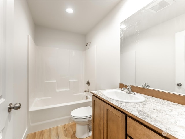 full bathroom with hardwood / wood-style flooring, shower / bathtub combination, vanity, and toilet