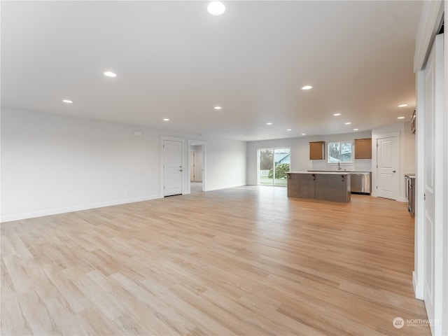 unfurnished living room featuring sink and light hardwood / wood-style floors