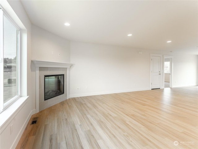 unfurnished living room featuring a fireplace and light hardwood / wood-style floors