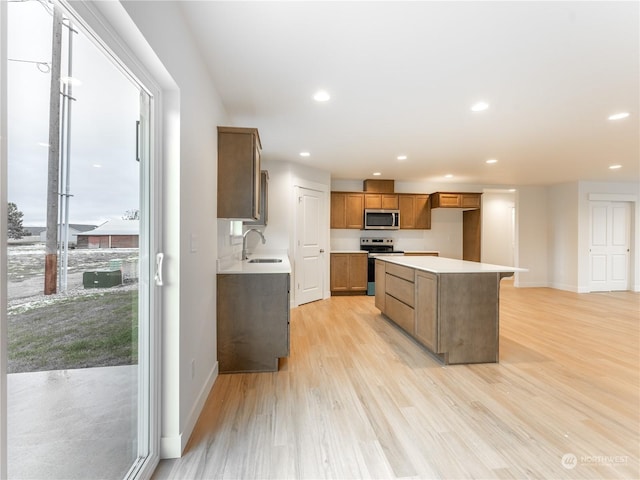 kitchen with stainless steel appliances, sink, a kitchen island, and a wealth of natural light