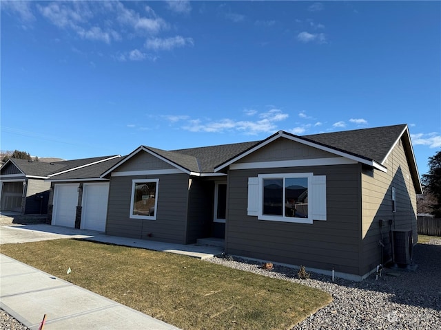 ranch-style home with a garage, a front yard, and central AC unit