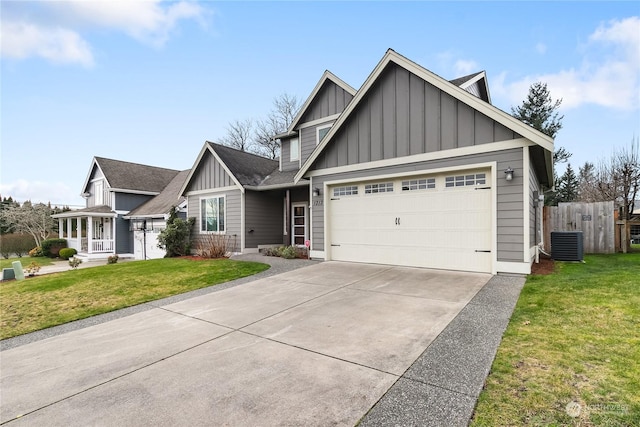 view of front of property featuring cooling unit, a garage, and a front lawn