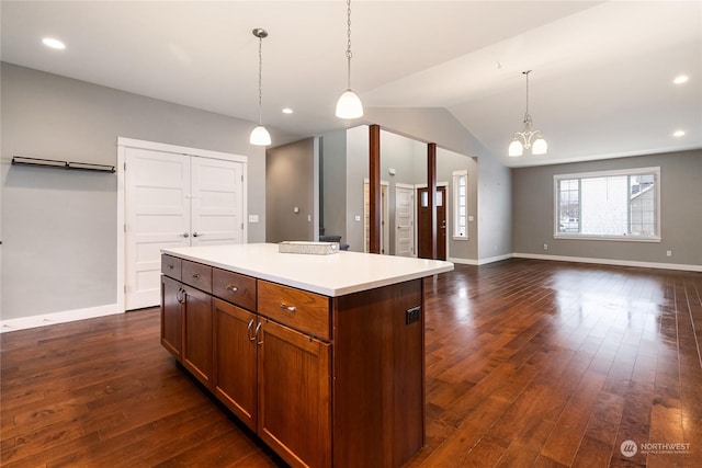 kitchen with vaulted ceiling, a kitchen island, decorative light fixtures, dark wood-type flooring, and an inviting chandelier