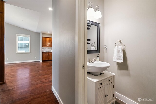 bathroom featuring vaulted ceiling, wood-type flooring, and vanity