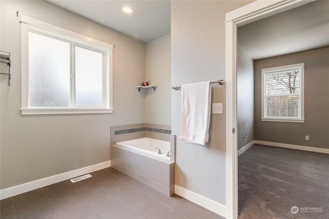 bathroom featuring tile patterned flooring and tiled tub