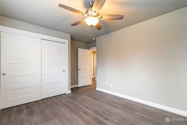 unfurnished bedroom featuring hardwood / wood-style flooring, ceiling fan, and a closet