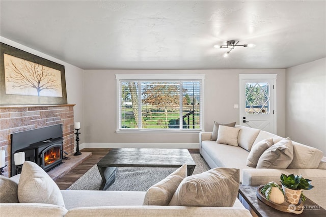 living room featuring a brick fireplace and wood-type flooring