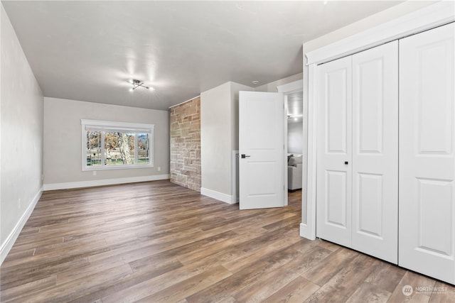 unfurnished bedroom featuring hardwood / wood-style floors and a closet