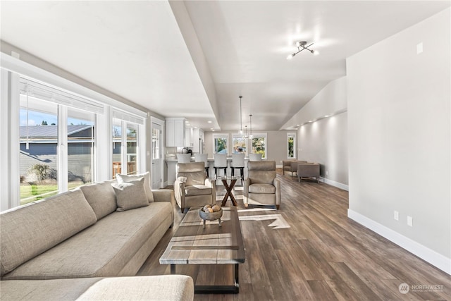 living room with vaulted ceiling, dark hardwood / wood-style floors, and a chandelier