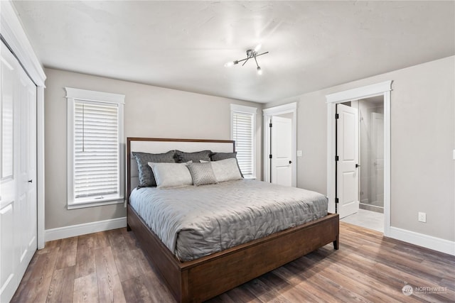 bedroom featuring a closet, hardwood / wood-style floors, and multiple windows