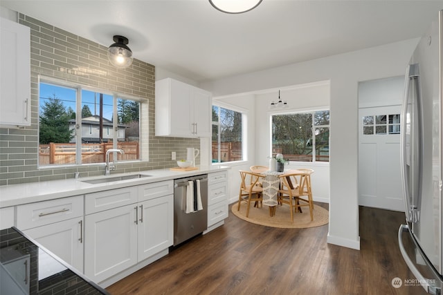 kitchen featuring tasteful backsplash, sink, white cabinets, and appliances with stainless steel finishes