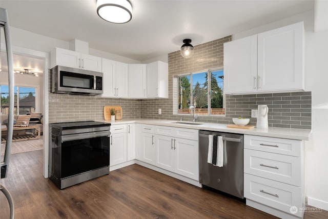 kitchen featuring appliances with stainless steel finishes, dark hardwood / wood-style floors, decorative backsplash, and white cabinets