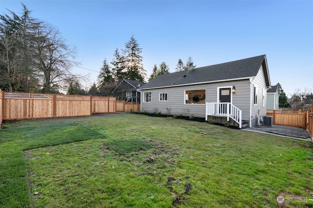 back of property featuring a yard and central AC unit