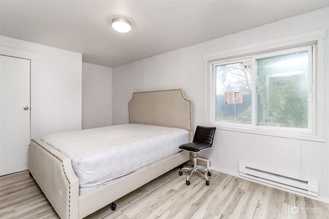 bedroom featuring light hardwood / wood-style floors and baseboard heating