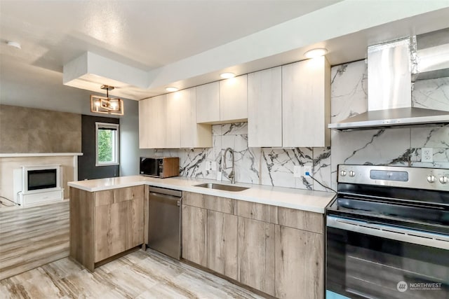 kitchen with appliances with stainless steel finishes, sink, decorative backsplash, and wall chimney range hood