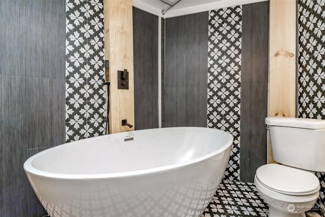 bathroom with tile patterned floors, toilet, and a bathtub