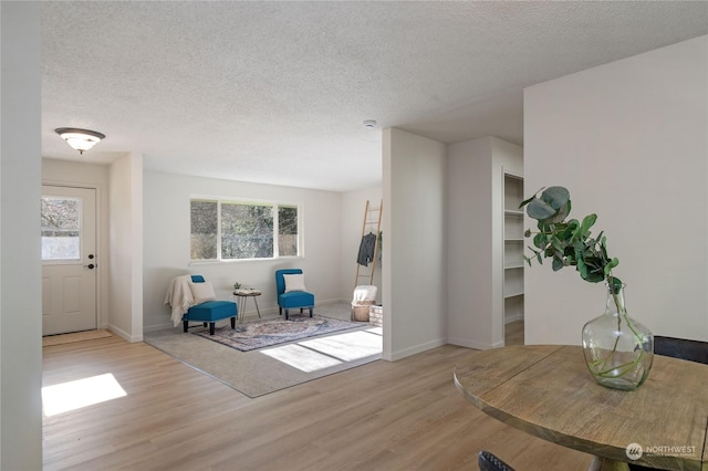 sitting room with a textured ceiling and light wood-type flooring