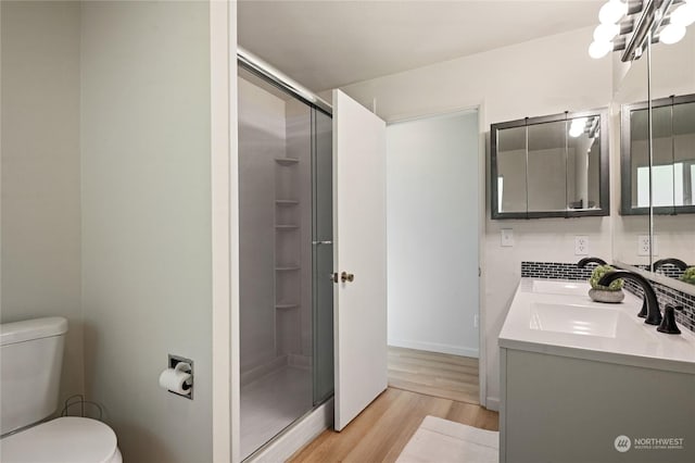 bathroom featuring walk in shower, vanity, toilet, and hardwood / wood-style floors