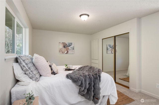 carpeted bedroom with a closet and a textured ceiling