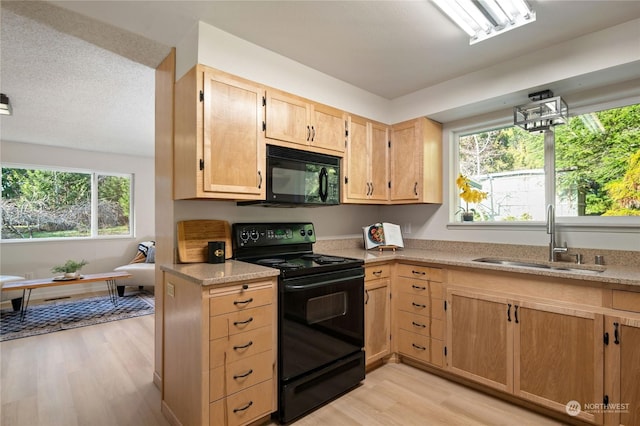 kitchen featuring sink, light hardwood / wood-style flooring, light brown cabinets, and black appliances