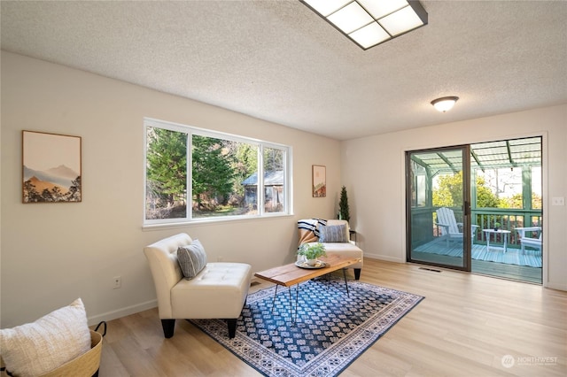 sitting room featuring a textured ceiling and light hardwood / wood-style flooring