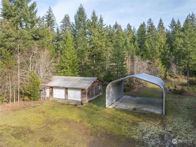 view of outbuilding with a carport, a garage, and a yard