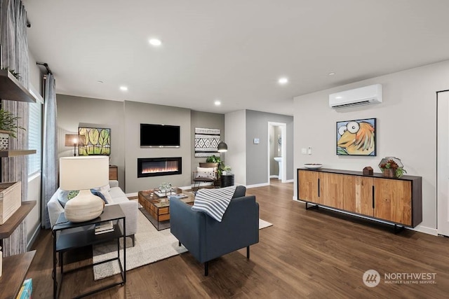 living room featuring baseboards, a glass covered fireplace, a wall unit AC, dark wood-style floors, and recessed lighting