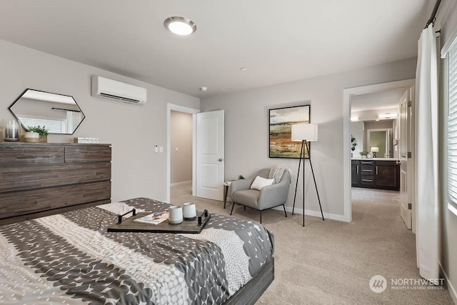 bedroom with ensuite bathroom, baseboards, light colored carpet, and a wall mounted AC