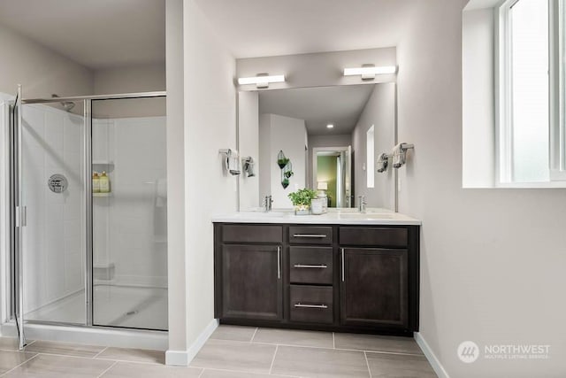 bathroom with double vanity, a stall shower, and a sink