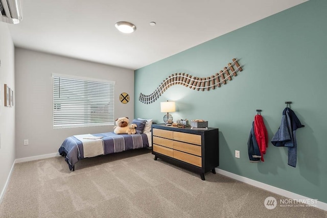 bedroom with light carpet, baseboards, and a wall mounted AC