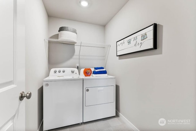 clothes washing area featuring laundry area, baseboards, and separate washer and dryer