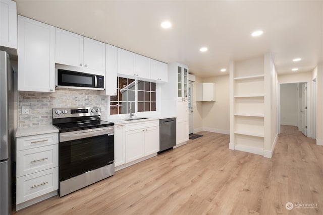 kitchen featuring stainless steel appliances, tasteful backsplash, white cabinets, and light hardwood / wood-style floors