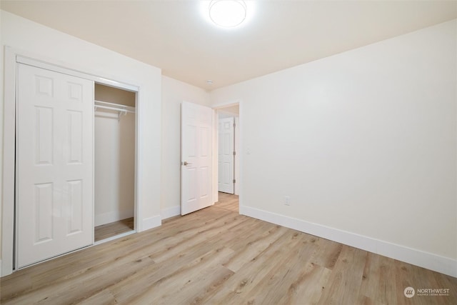 unfurnished bedroom with light hardwood / wood-style floors and a closet