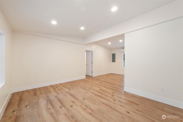 unfurnished room featuring a wall mounted air conditioner and light wood-type flooring