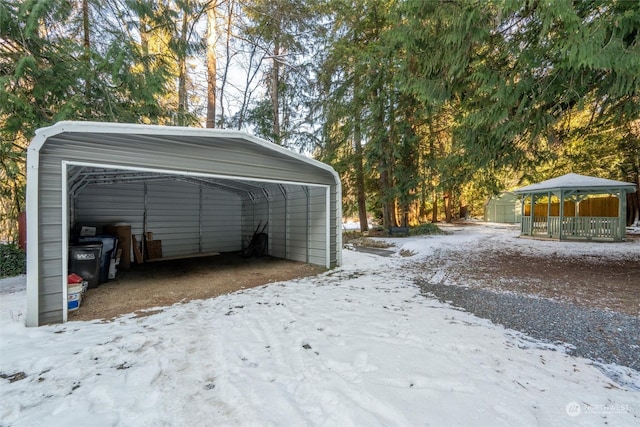 snow covered garage with a carport