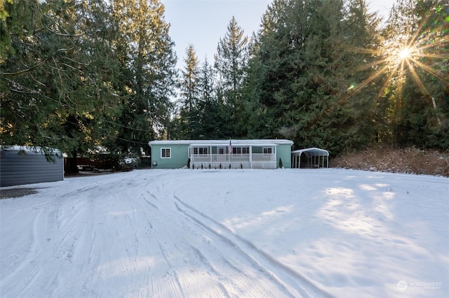 snow covered structure featuring a carport