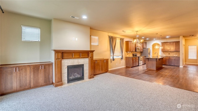 unfurnished living room with a tile fireplace and carpet flooring