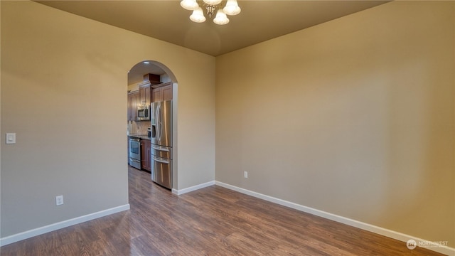 unfurnished room with dark hardwood / wood-style floors and a chandelier