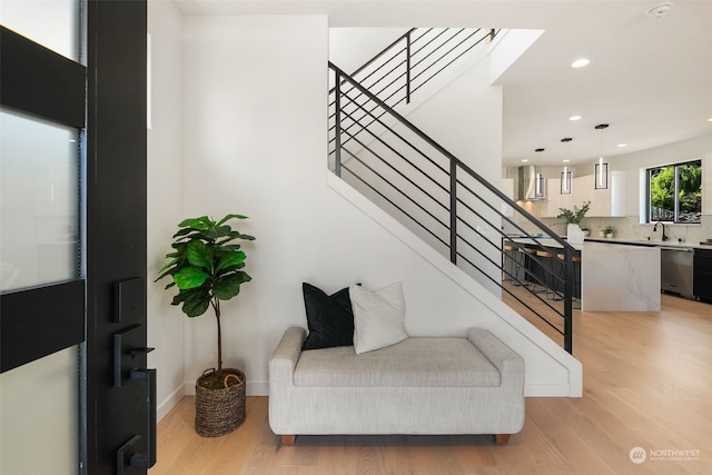 stairs featuring sink and wood-type flooring