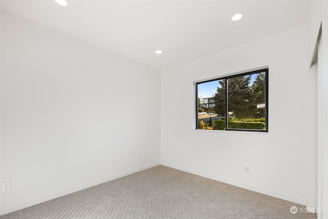 spare room featuring light carpet