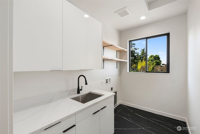 clothes washing area with cabinets, hookup for a washing machine, sink, and electric dryer hookup