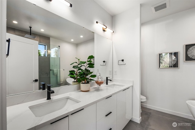 bathroom with vanity, a shower with door, and toilet