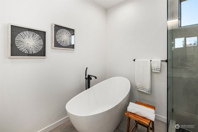 bathroom with a tub to relax in and tile patterned flooring